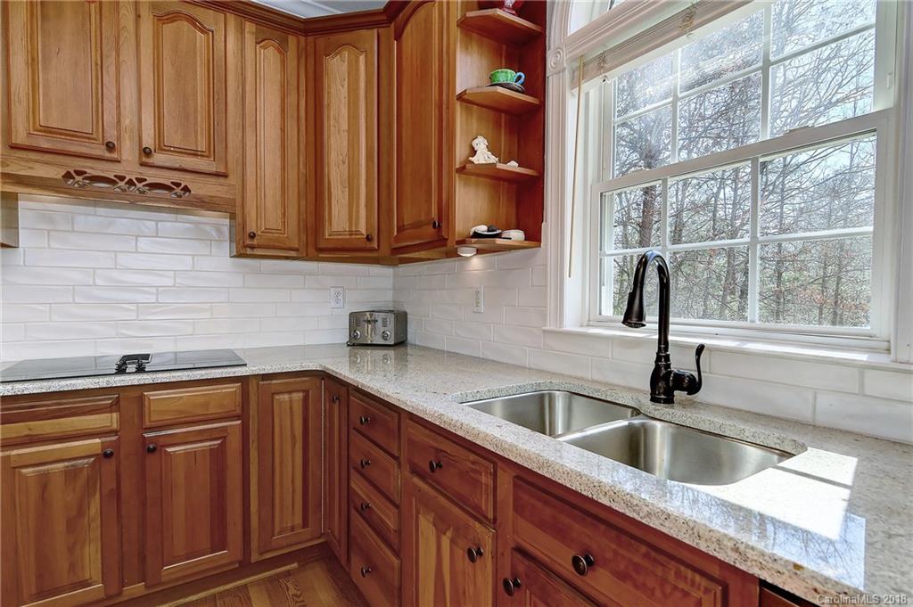 3203 Planters Ridge Road Charlotte, NC 28270 - Photo 6 of 36 a kitchen with stainless steel appliances granite countertop a sink and a wooden cabinets