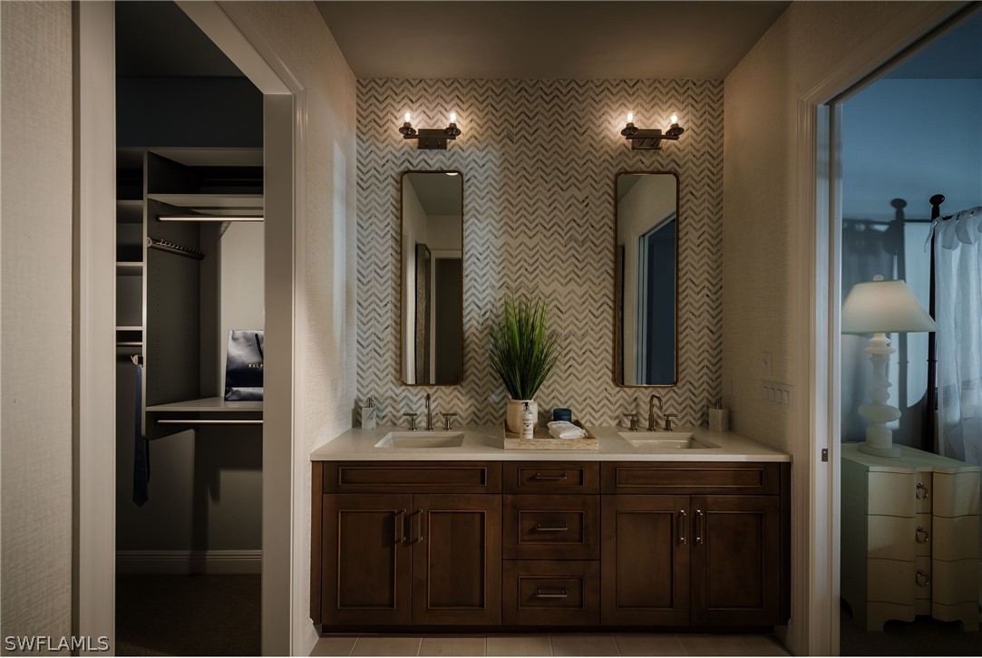 14831 Loggerhead Drive Naples, FL 34120 - Photo 8 of 10 a bathroom with a double vanity sink and mirror