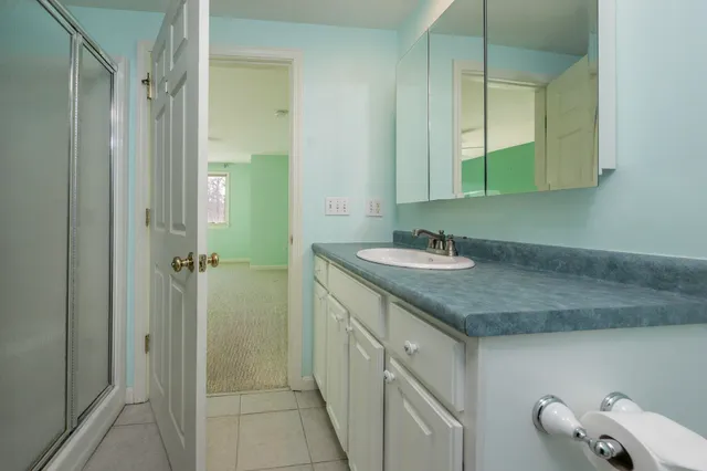 a bathroom with a granite countertop sink and a mirror