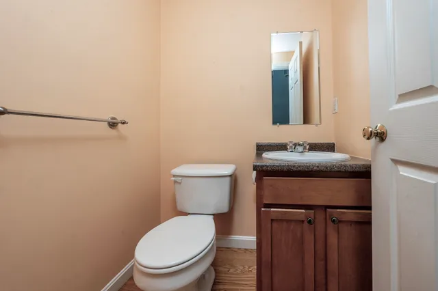 a bathroom with a granite countertop toilet sink and mirror