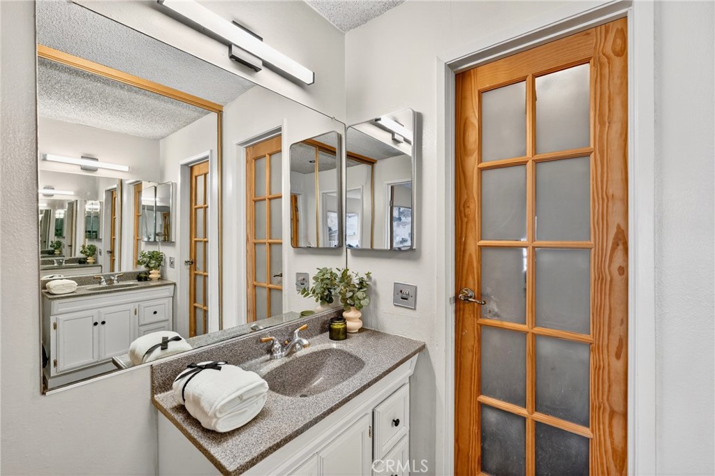 5585 Pacific Coast Highway, Unit 161 Long Beach, CA 90804 - Photo 15 of 44 a bathroom with a granite countertop sink mirror and a shower