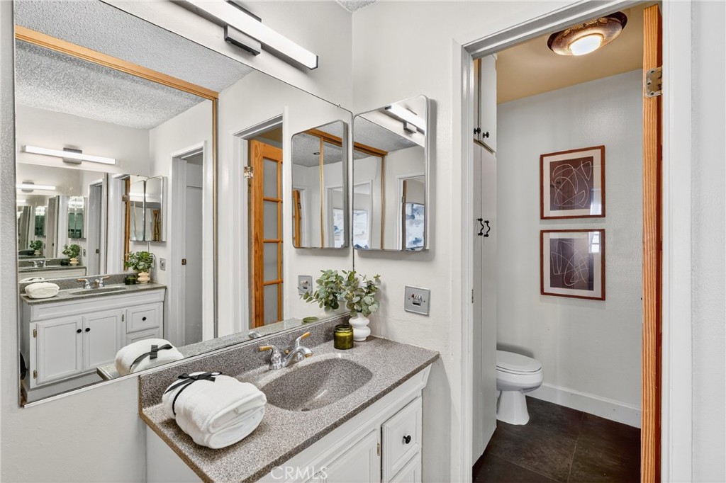 5585 Pacific Coast Highway, Unit 161 Long Beach, CA 90804 - Photo 20 of 44 a bathroom with a granite countertop sink mirror and a bathtub