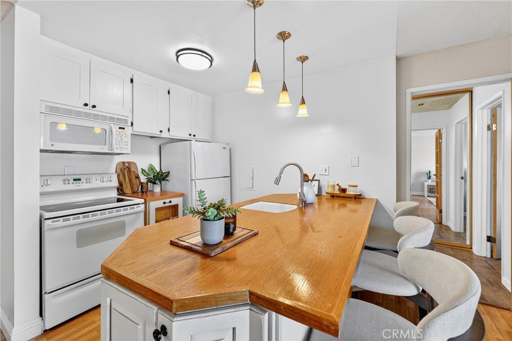 5585 Pacific Coast Highway, Unit 161 Long Beach, CA 90804 - Photo 4 of 44 a kitchen with a table chairs and a refrigerator