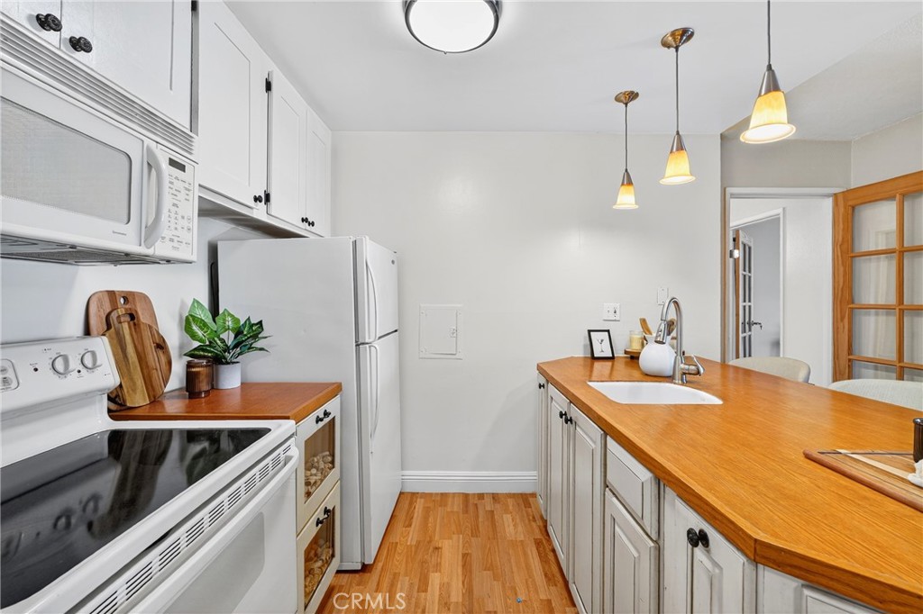 5585 Pacific Coast Highway, Unit 161 Long Beach, CA 90804 - Photo 6 of 44 a kitchen with stainless steel appliances granite countertop a sink a stove and a wooden floors