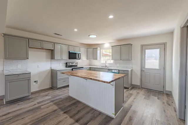 a kitchen with a sink stove cabinets and refrigerator