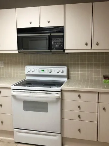 a stove top oven sitting inside of a kitchen