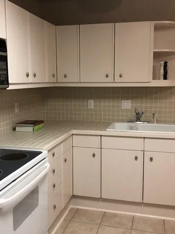 a kitchen with granite countertop white cabinets and white appliances
