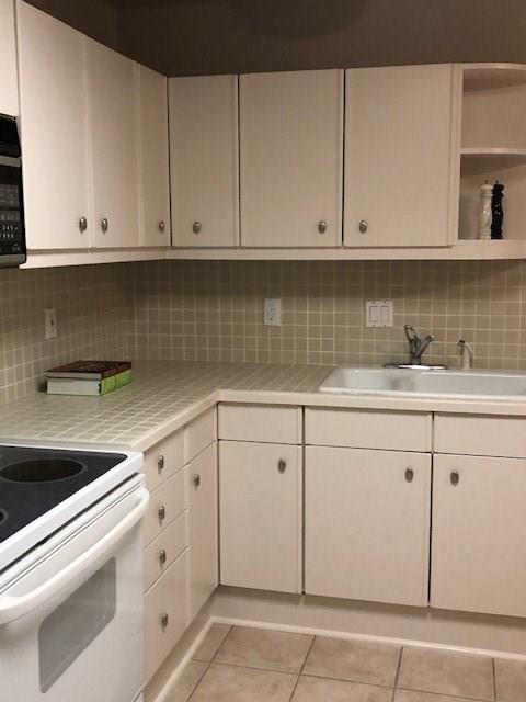 40 North Interstate Highway 35, Unit 2A2 Austin, TX 78701 - Photo 9 of 28 a kitchen with granite countertop white cabinets and white appliances