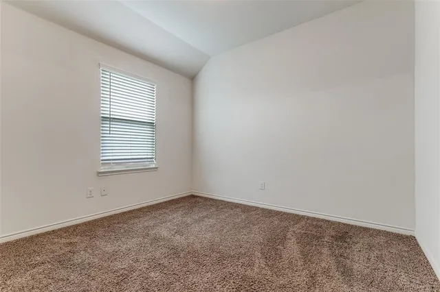 an empty room with closet and windows