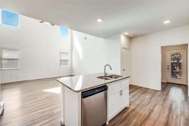 a kitchen that has a sink a stove and wooden floor