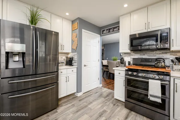 a kitchen with stainless steel appliances and wooden floor