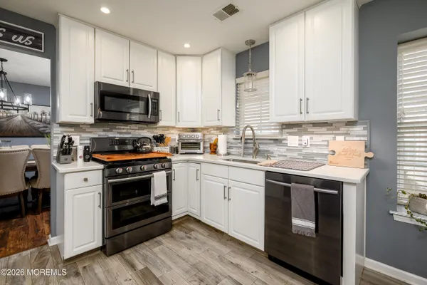 a kitchen with stainless steel appliances granite countertop a stove a sink and a microwave