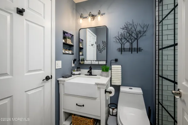 a bathroom with a sink vanity mirror and toilet