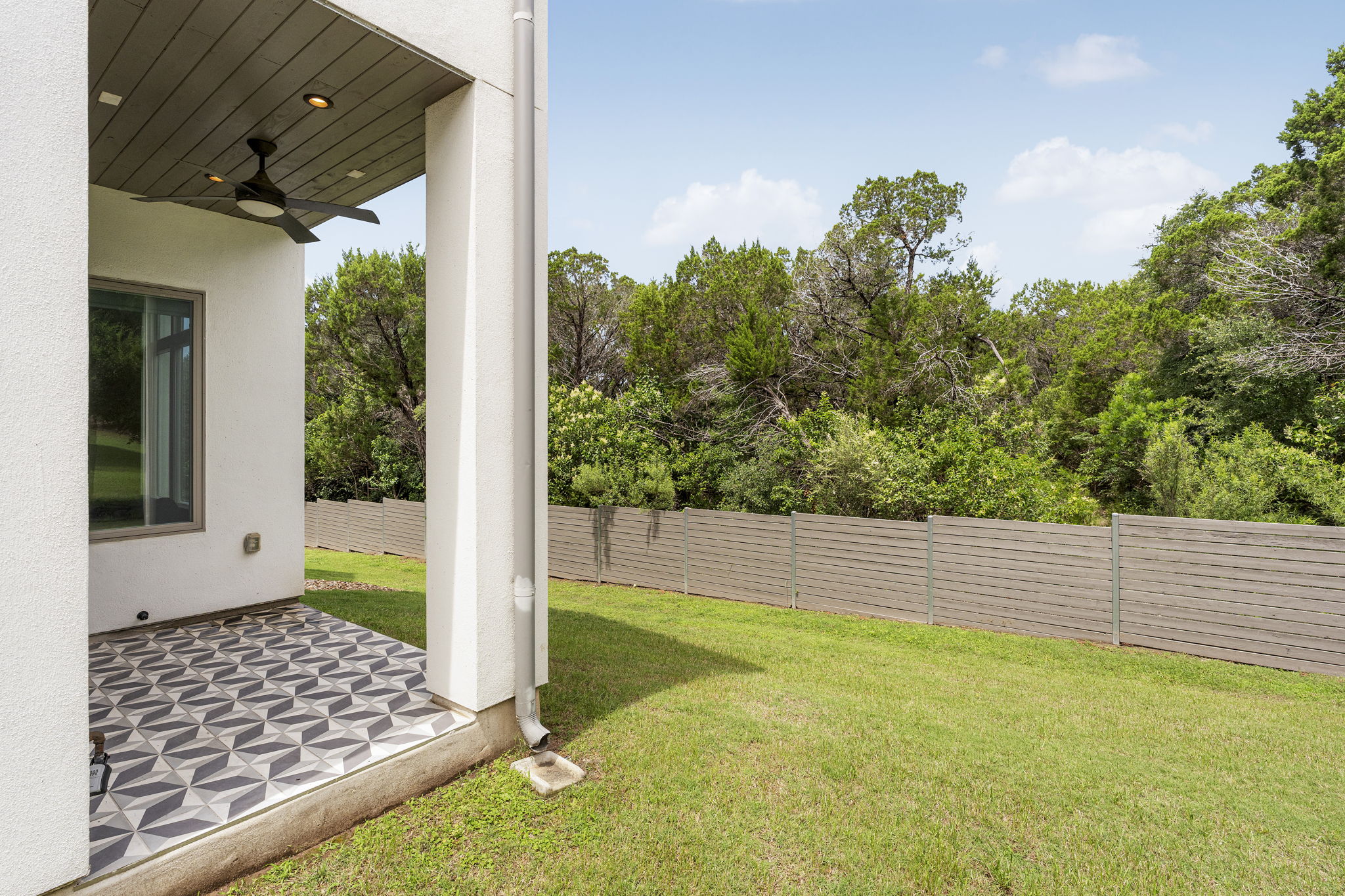 2520 Sutherland Street Austin, TX 78746 - Photo 25 of 26 Backing to a Greenbelt the backyard oasis is lush greenery and the covered patio has outdoor grass grill hookup, beautiful tile work and gorgeous ceiling woodwork.