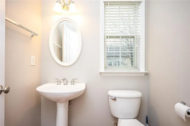 a bathroom with a toilet sink and mirror