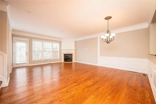 a view of empty room with wooden floor and window