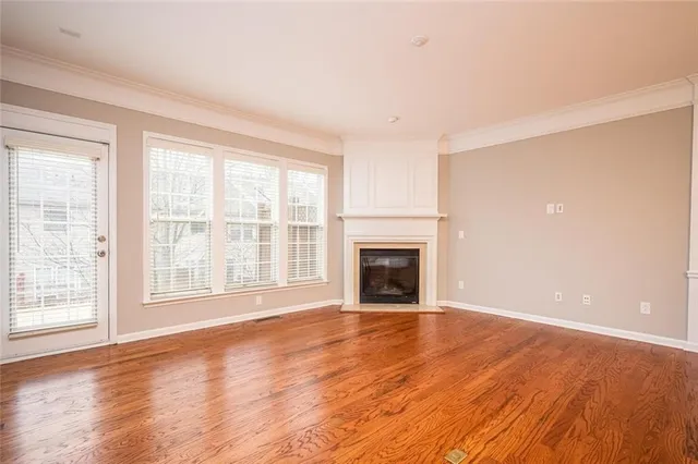 a view of empty room with wooden floor and fireplace