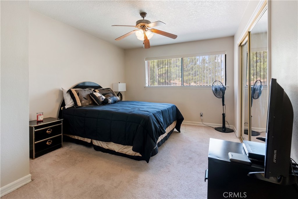 17656 Mockingbird Hill Circle Riverside, CA 92504 - Photo 24 of 49 a bedroom with a bed and a flat tv screen on a dresser