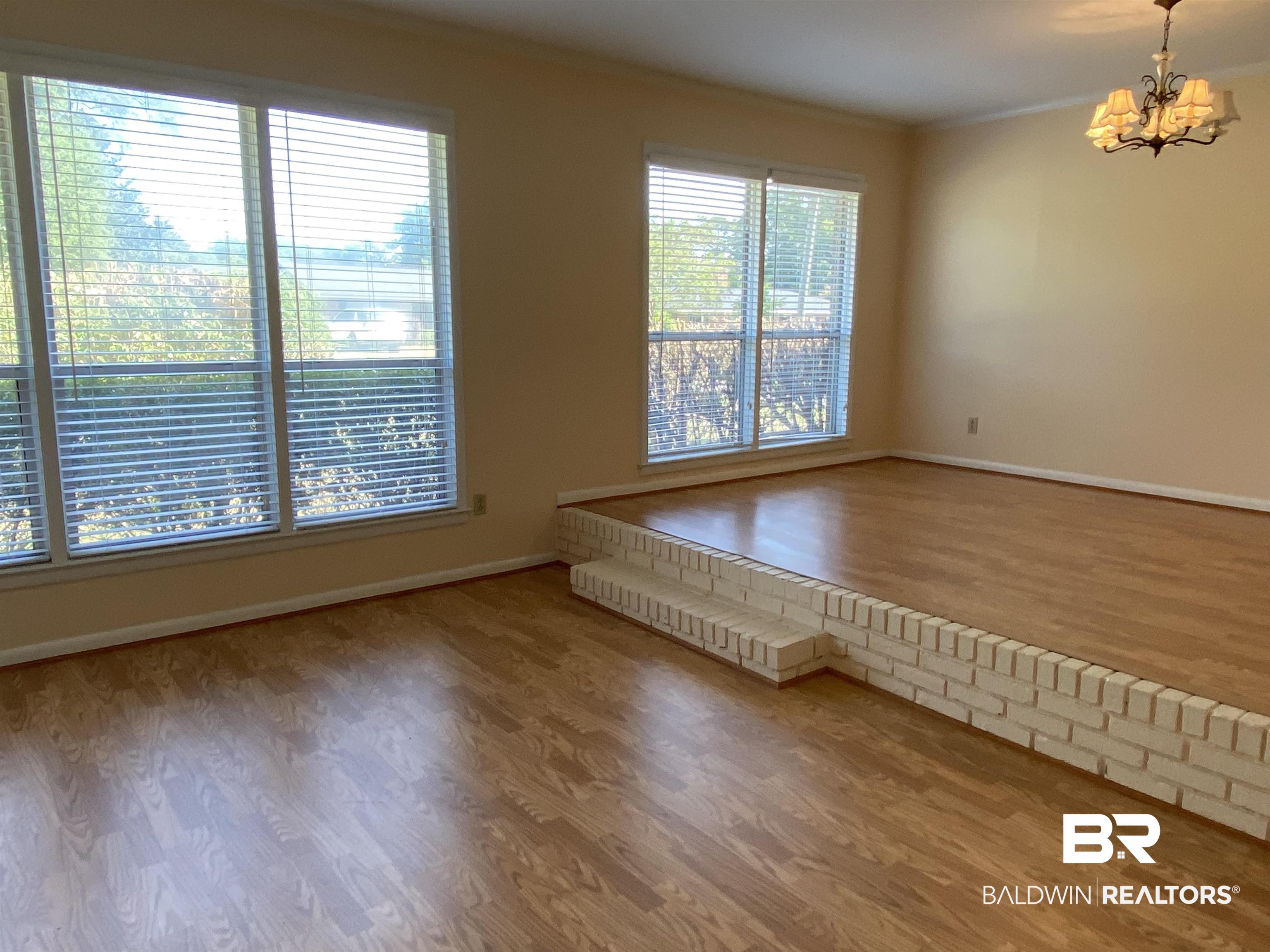106 Terry Drive Brewton, AL 36426 - Photo 5 of 25 Room with light wood-type flooring, crown molding, and a chandelier