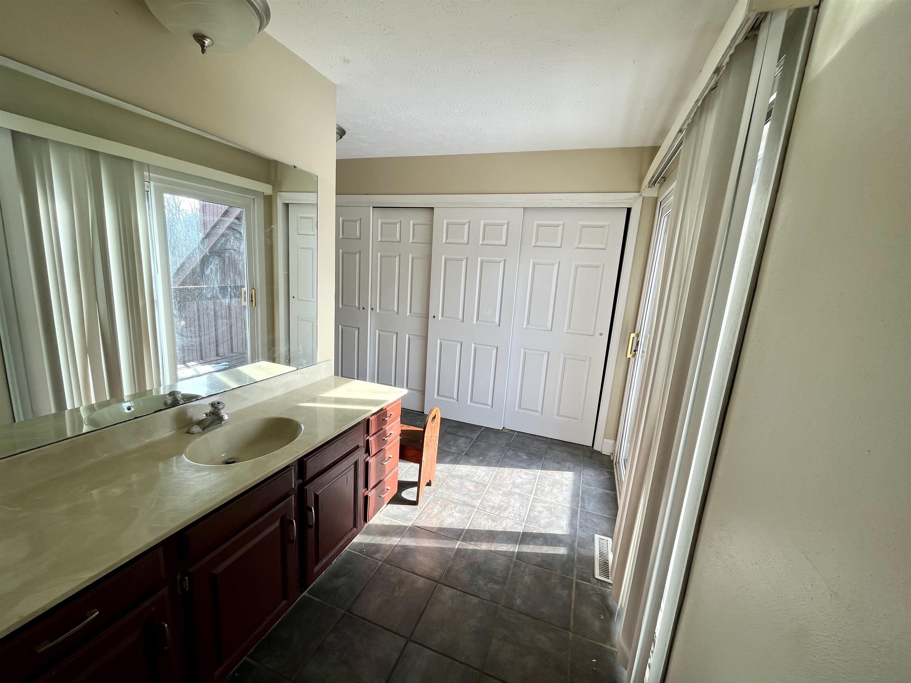 5051 Woodlake Drive Loves Park, IL 61111 - Photo 17 of 20 a bathroom with a granite countertop sink and a large mirror