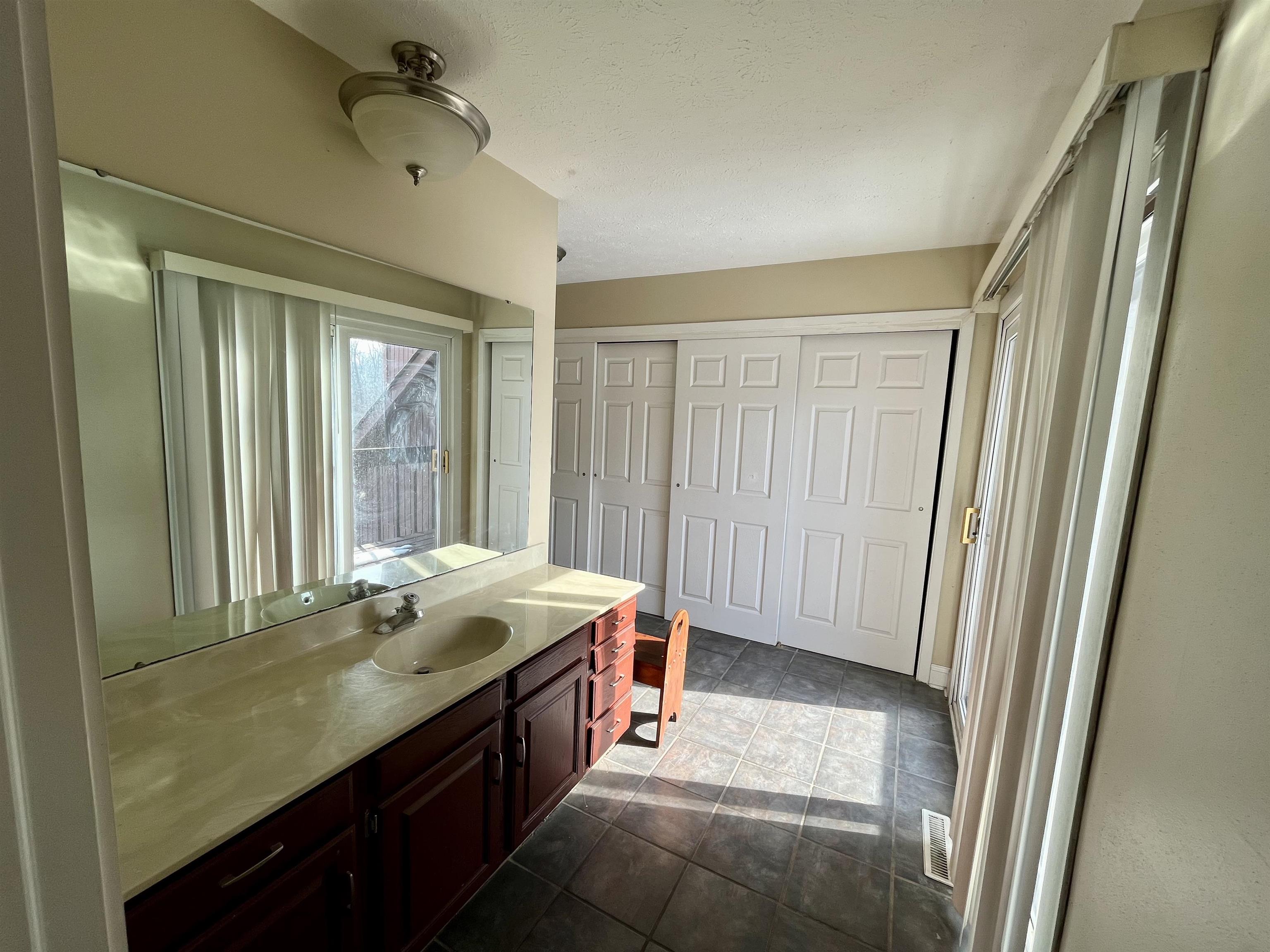 5051 Woodlake Drive Loves Park, IL 61111 - Photo 18 of 20 a bathroom with a granite countertop sink a mirror and a bathtub