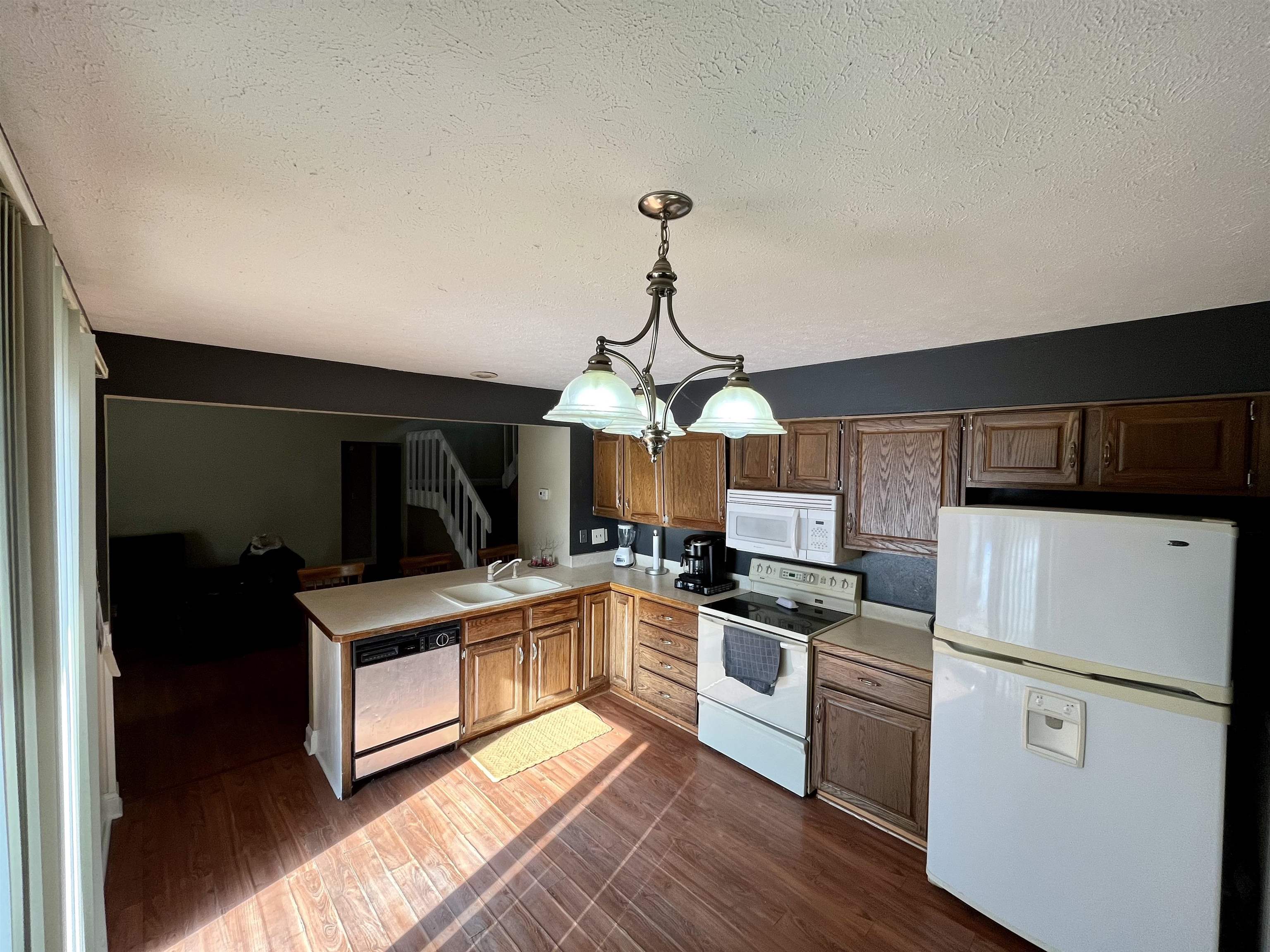 5051 Woodlake Drive Loves Park, IL 61111 - Photo 2 of 20 a kitchen with granite countertop a stove top oven a sink dishwasher and a refrigerator with wooden floor
