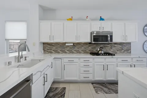 a kitchen with cabinets stainless steel appliances a sink and a stove