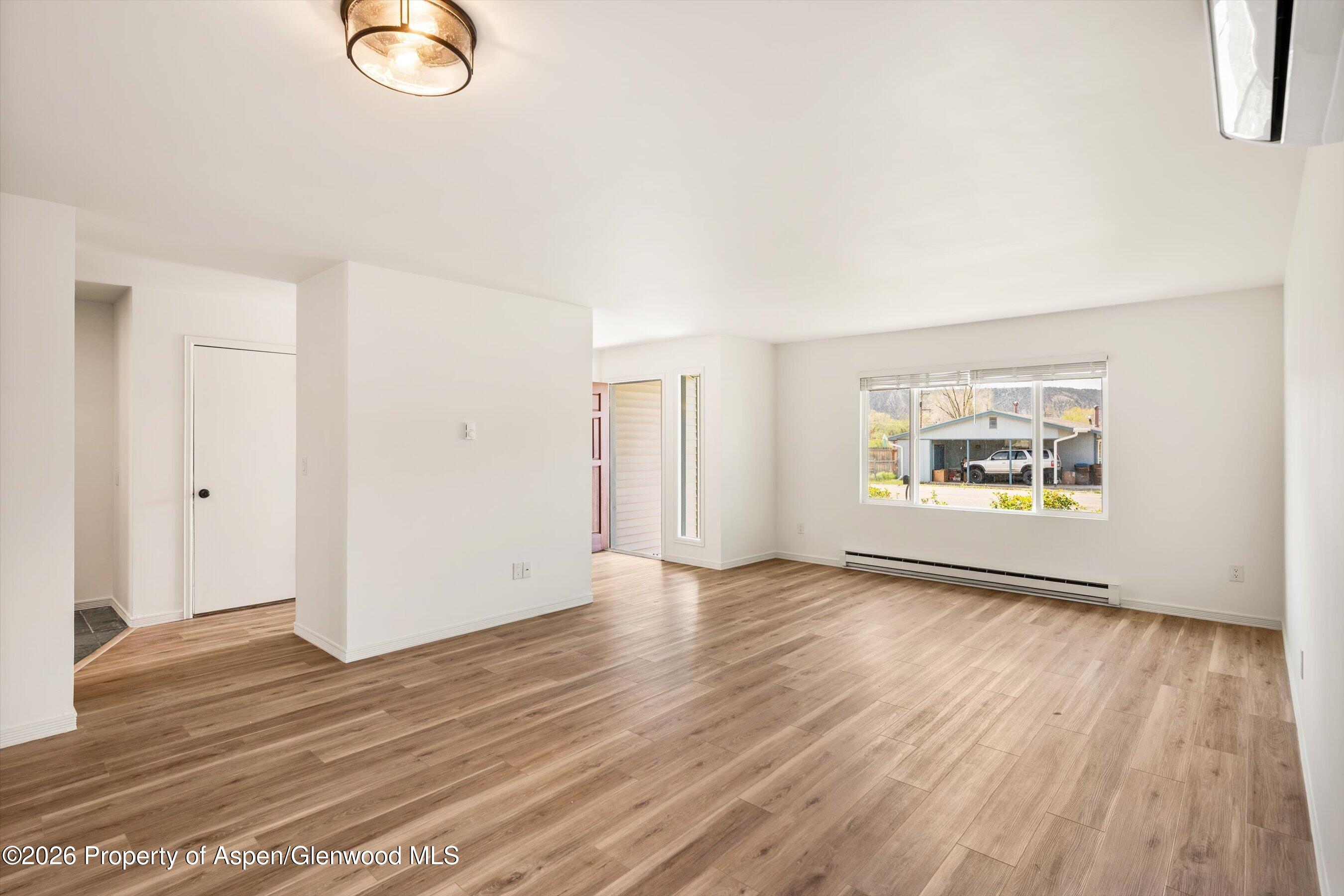 942 West 5th Street Rifle, CO 81650 - Photo 3 of 23 an empty room with wooden floor and window