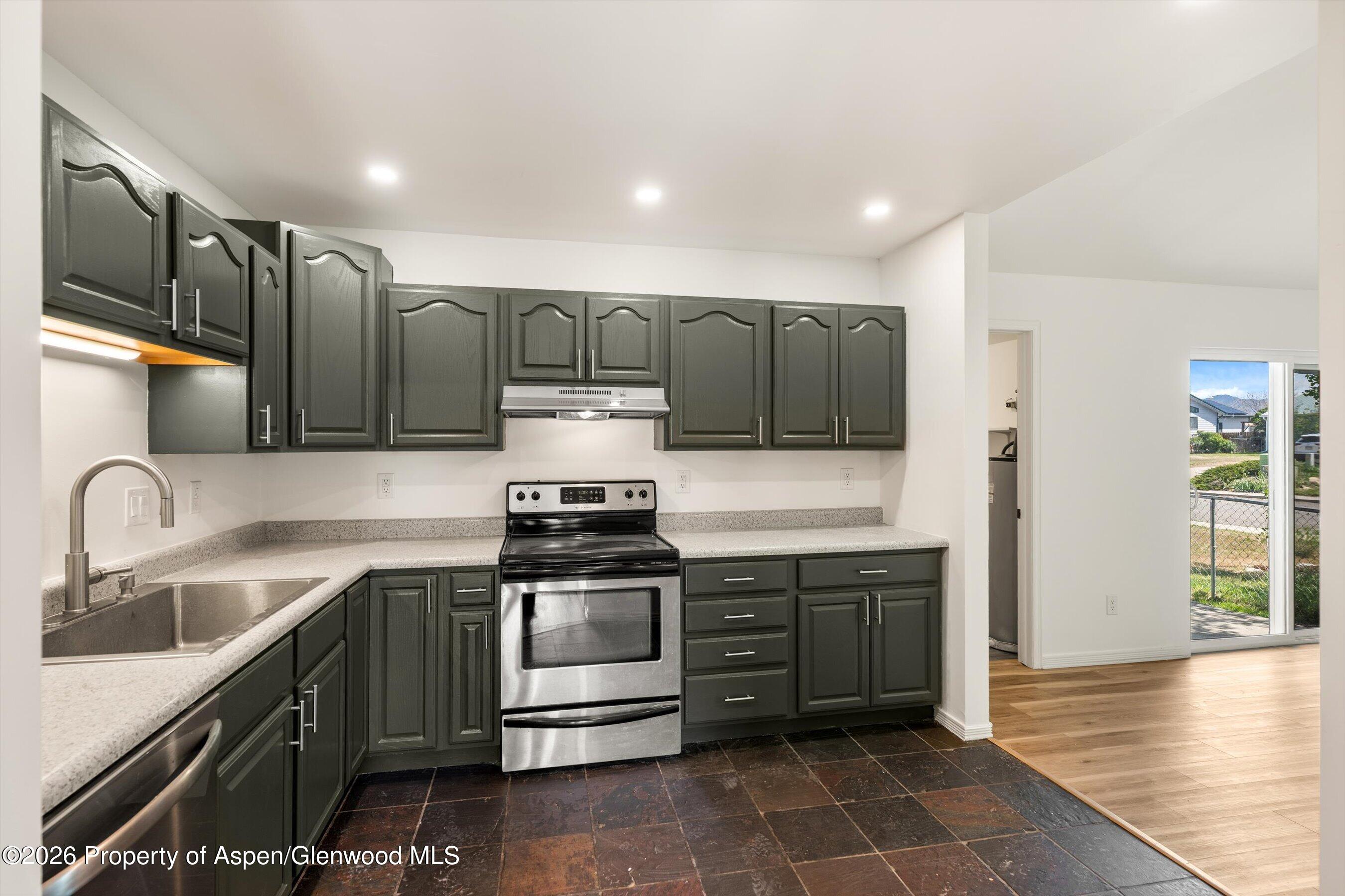 942 West 5th Street Rifle, CO 81650 - Photo 7 of 23 a kitchen with stainless steel appliances granite countertop a sink and a stove
