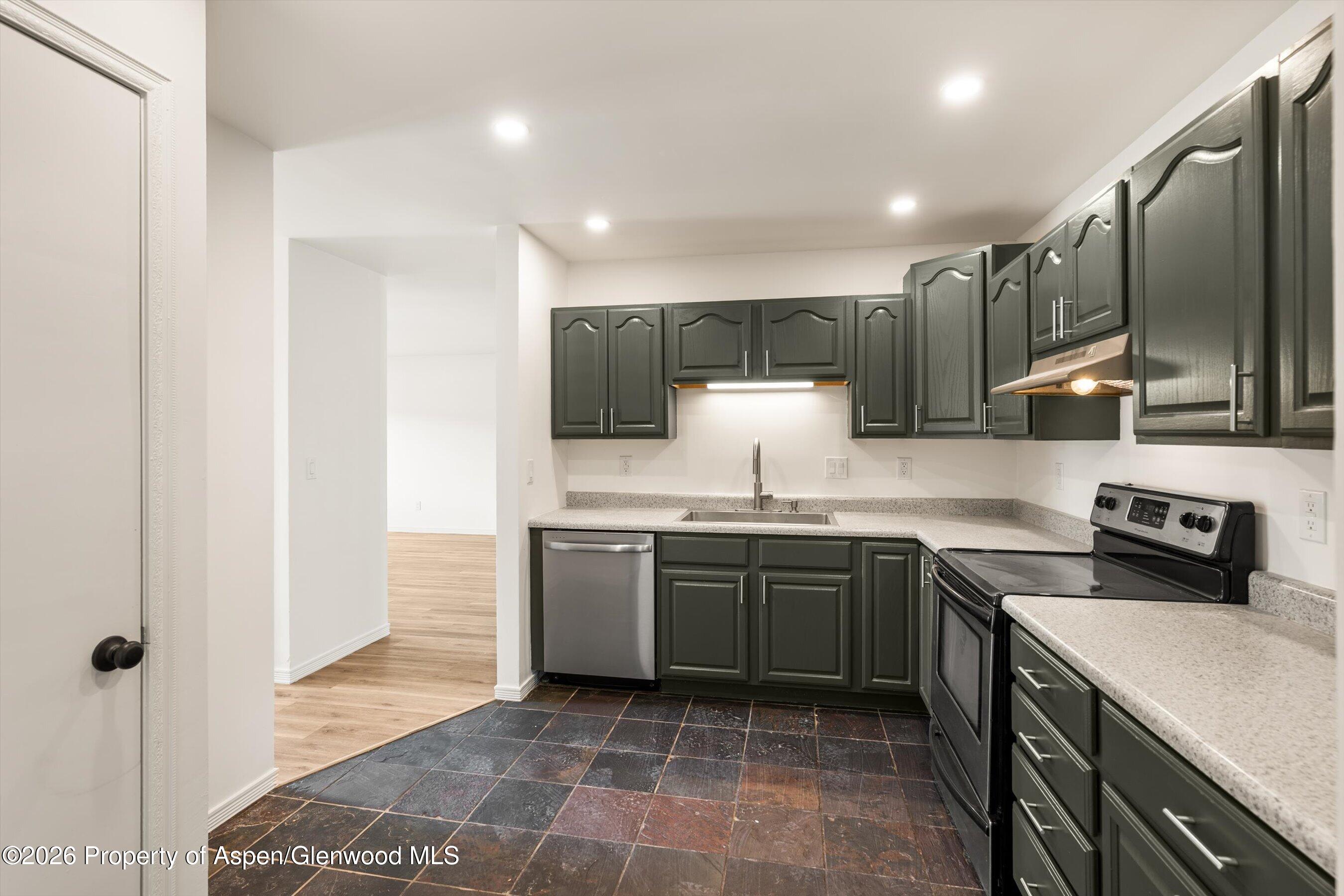 942 West 5th Street Rifle, CO 81650 - Photo 8 of 23 a kitchen with stainless steel appliances granite countertop a sink a stove a refrigerator and cabinets