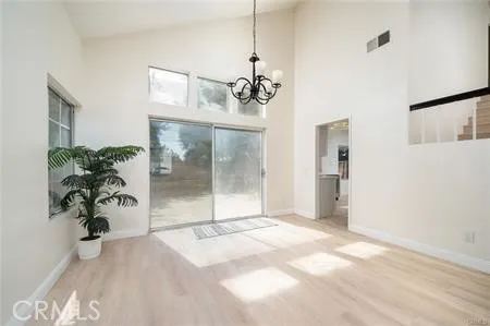 a view of a big room with wooden floor and windows