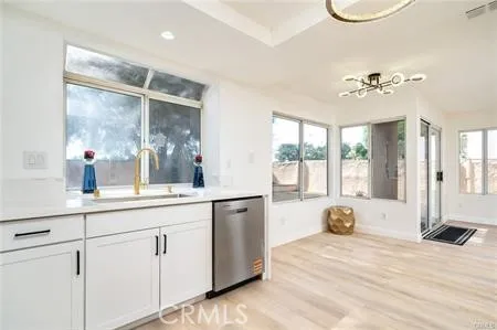 a kitchen with stainless steel appliances granite countertop white cabinets a sink a stove a microwave and cabinetry