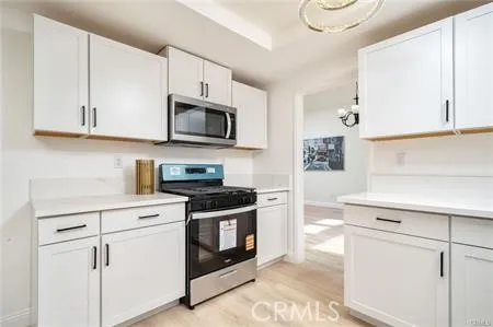 a kitchen with granite countertop white cabinets and white appliances