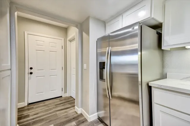 a kitchen with a refrigerator and wooden floor