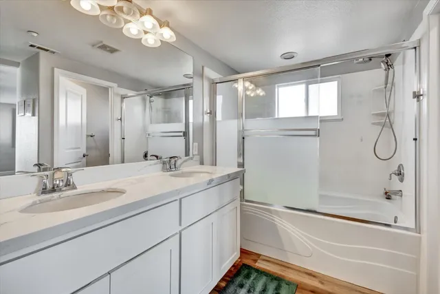a bathroom with a granite countertop sink a mirror a vanity and a shower