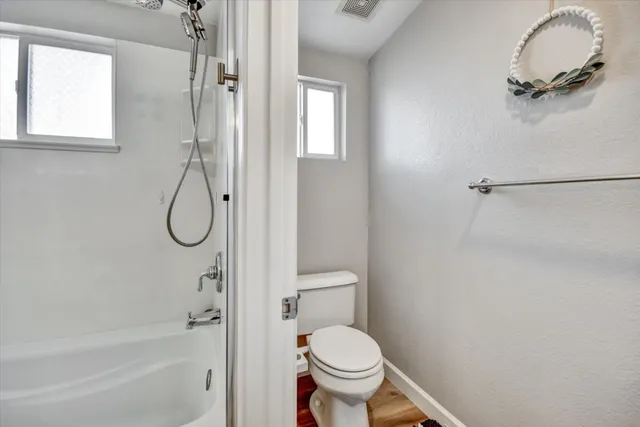 a bathroom with a granite countertop toilet and a shower