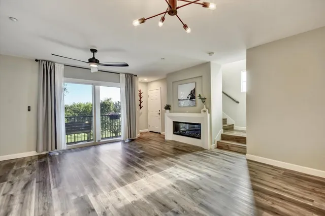 wooden floor fireplace and windows in an empty room