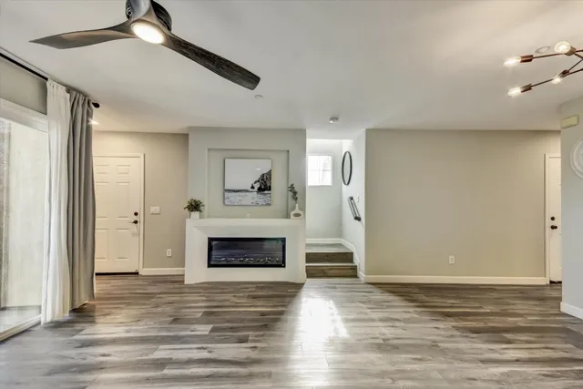 a view of empty room with wooden floor and fireplace