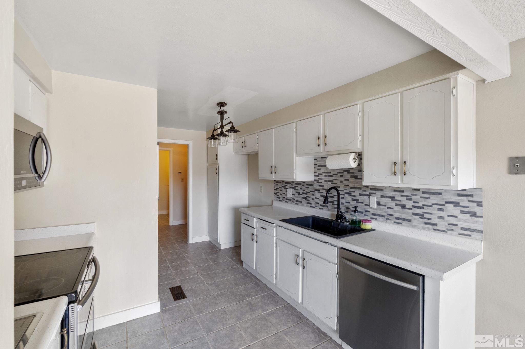 68 Condor Circle Carson City, NV 89701 - Photo 14 of 33 a kitchen with stainless steel appliances a stove a sink and a refrigerator
