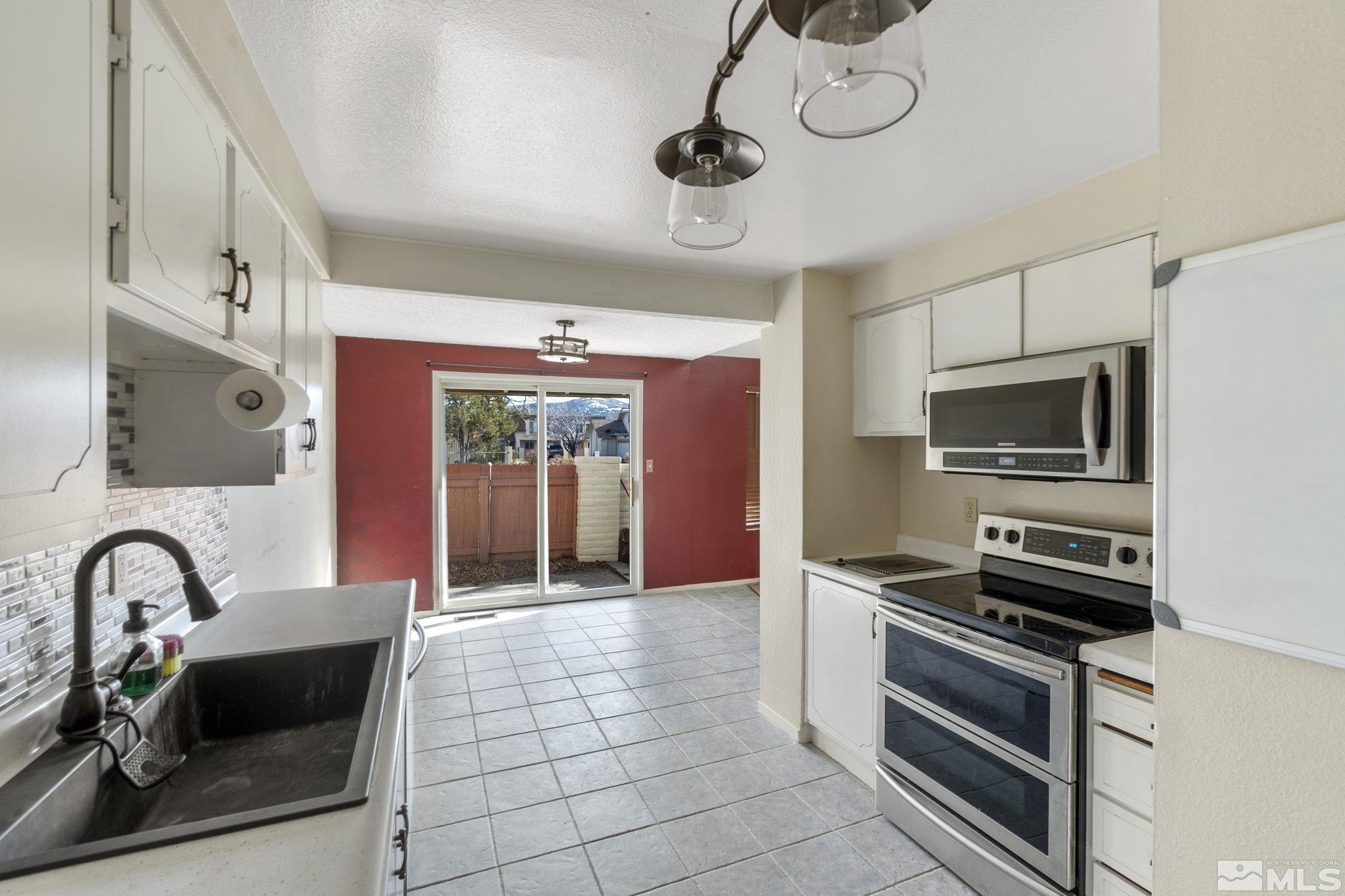 68 Condor Circle Carson City, NV 89701 - Photo 17 of 33 a kitchen with stainless steel appliances granite countertop a stove and a microwave