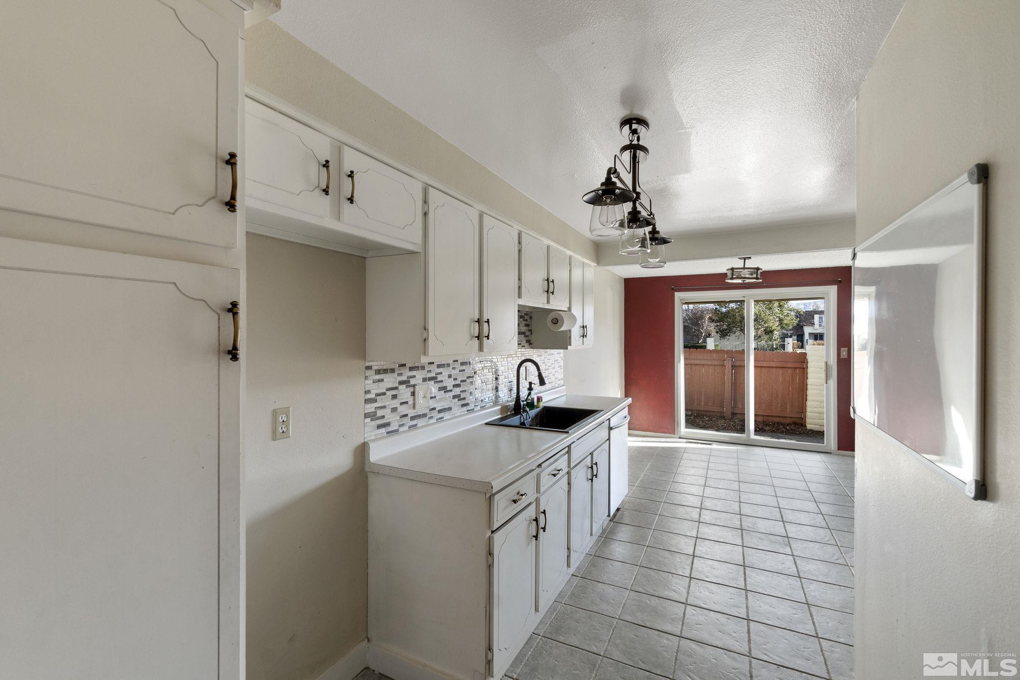 68 Condor Circle Carson City, NV 89701 - Photo 18 of 33 a kitchen with granite countertop a sink stove and cabinets