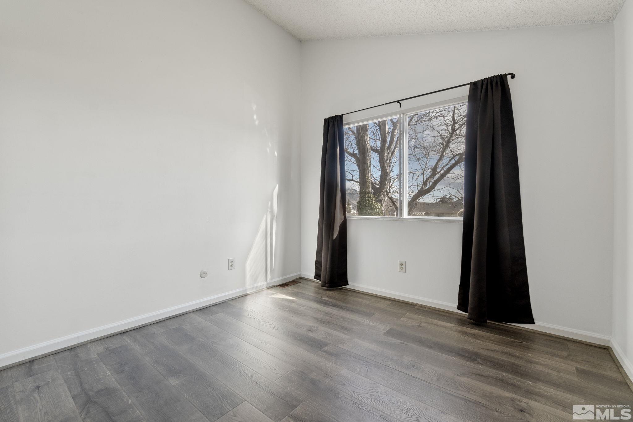 68 Condor Circle Carson City, NV 89701 - Photo 31 of 33 an empty room with wooden floor and windows