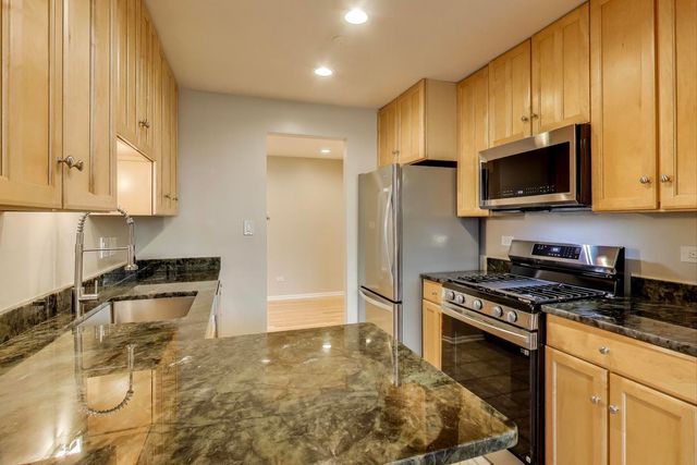 a kitchen with refrigerator and cabinets