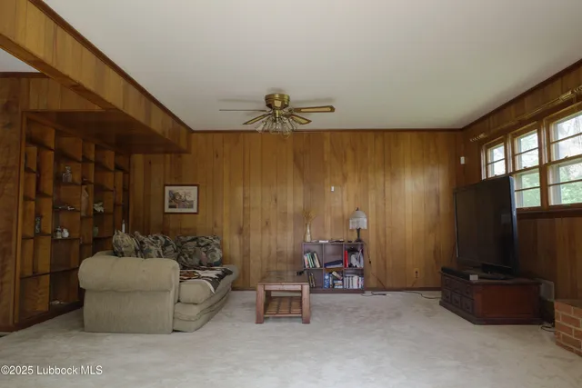 a living room with furniture and a ceiling fan