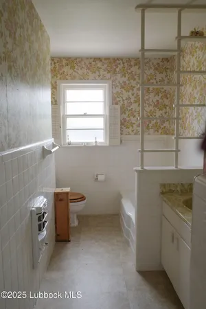 a bathroom with a toilet sink and window