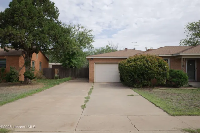 front view of house with a yard and trees around