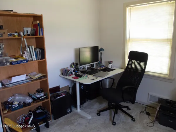 a view of a workspace with furniture and a window