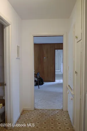 a view of a hallway with wooden shelves