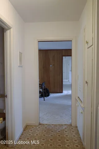 a view of a hallway with wooden shelves