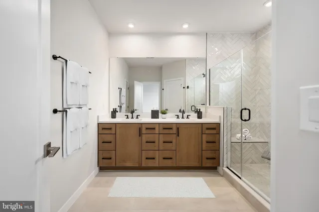 a bathroom with a double vanity sink a mirror a bathtub and shower